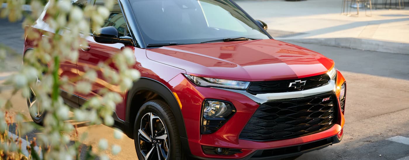 A red 2023 Chevy Trailblazer RS is shown parked on the side of a city street.