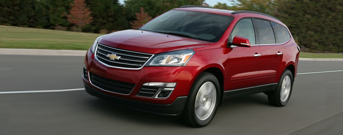 A red 2017 Chevy Traverse LTZ is shown driving on a highway.