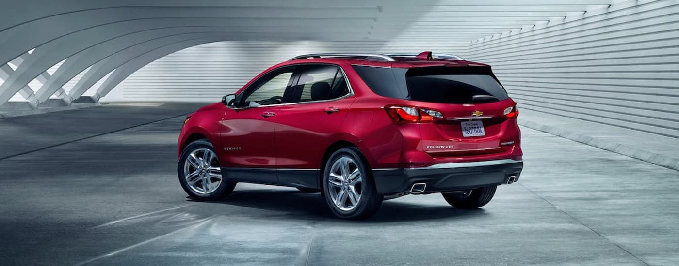 A red 2019 Chevy Equinox is shown from the side parked in an air-hanger.
