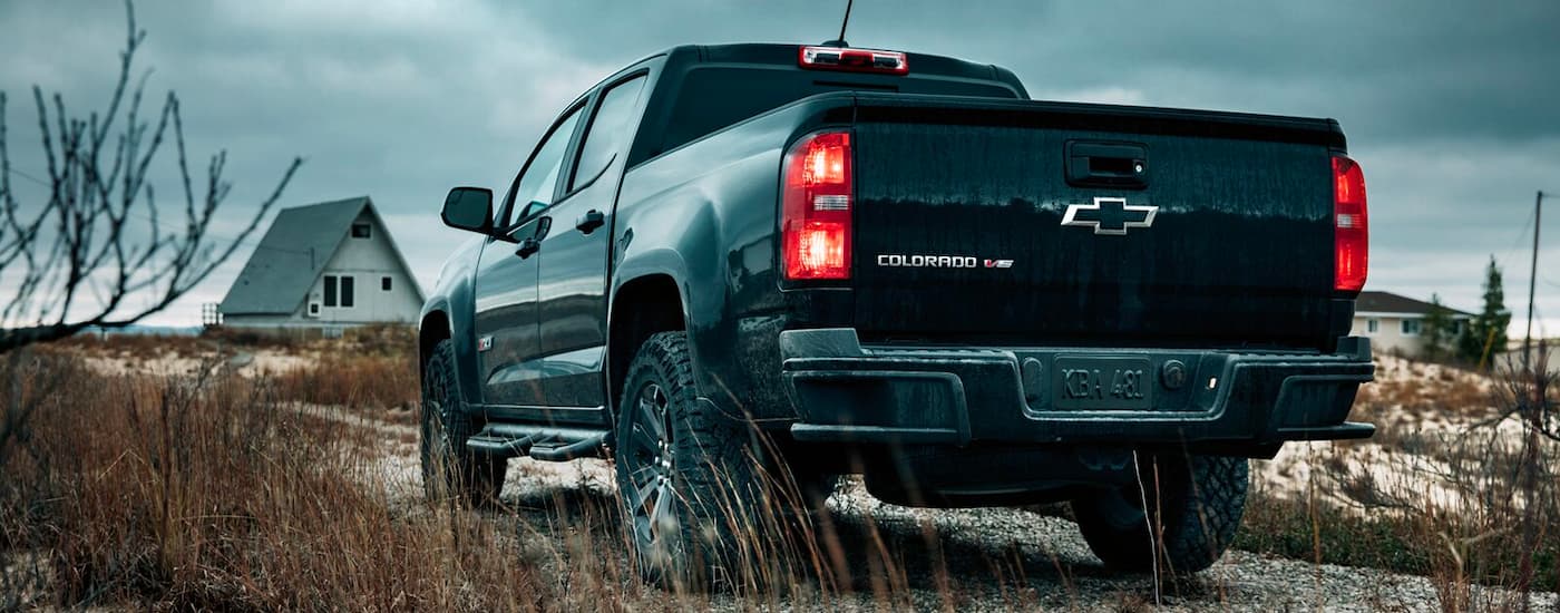 A 2018 Chevy Colorado Z71 is shown from the rear after leaving a used car lot near you.