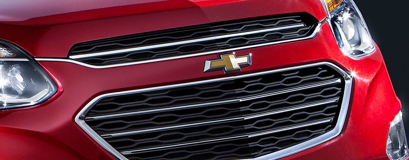 A closeup shows the grille on a red 2016 used Chevy Equinox.