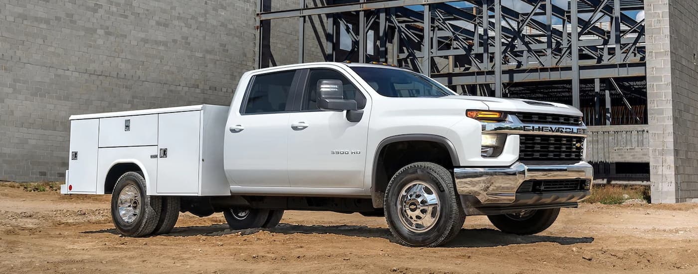 A white 2022 Chevy Silverado 3500HD is shown parked at a construction site.