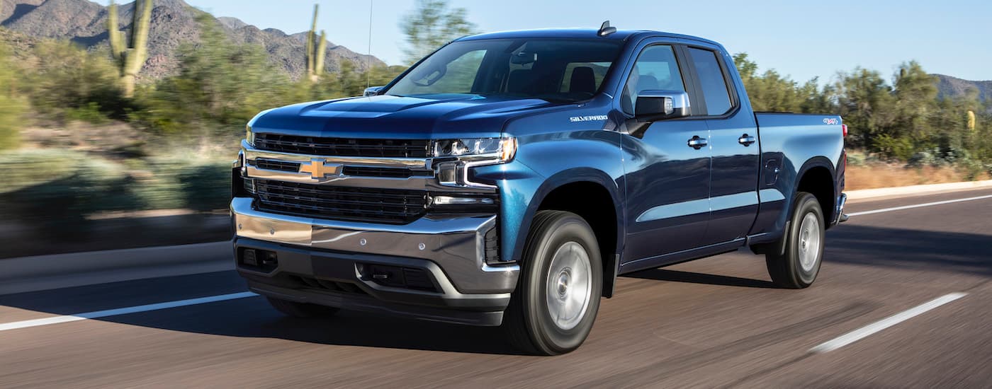 A blue 2019 used Chevy Silverado near you is shown driving on an open highway.