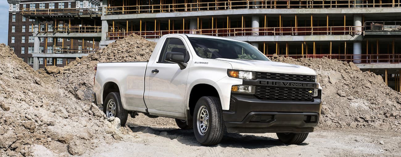 A white 2020 Chevy Silverado 1500 Work Truck is shown parked on a construction site.